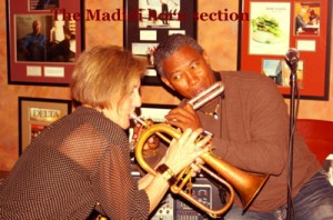 A woman plays a flugelhorn with a man.