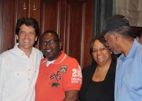 Four people smiling at a gathering.