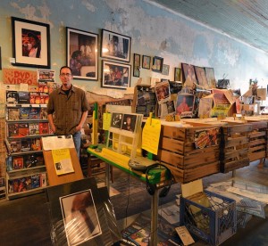 Man in a record store looking at vinyl records.