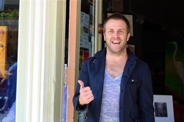 Smiling man in blue jacket giving thumbs up.