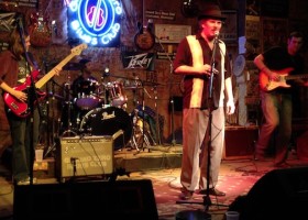 A band performs on stage at a blues club.