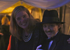 Two women, one wearing a hat, smiling.