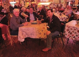 Four men sitting at a table in a diner.