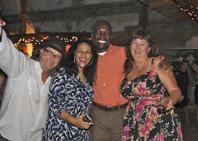 Four friends smiling at a social gathering.