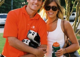 Couple holding sports equipment and drinks.