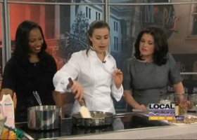 Three women cooking in a kitchen studio.