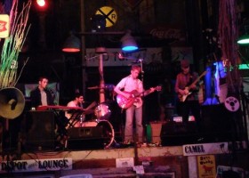 Live band playing on a stage at a bar.