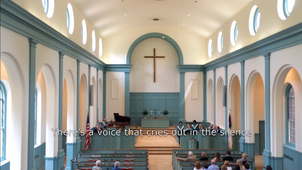 A church interior with a cross above the altar.