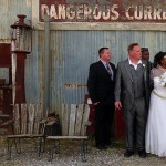 Wedding party posing in front of a sign.