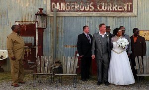 Wedding party posing in front of a sign.