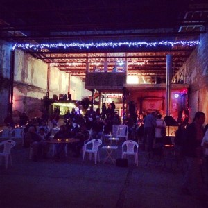 People gather in a dimly lit warehouse.