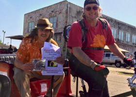 Two men in a rickshaw holding a CD release flyer.