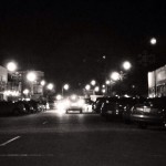 Nighttime street scene with cars and streetlights.