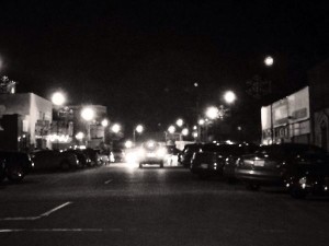 Nighttime street scene with cars and streetlights.