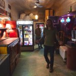 Man in bar with a drink menu and customers.