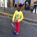 Young girl in yellow shirt playing with string.