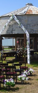 Rustic silo wedding ceremony setup with flowers.