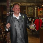 Man in a suit holding flowers in a store.