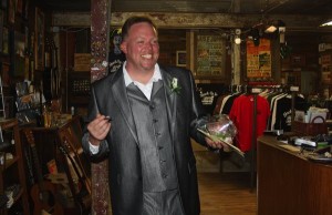 Man in a suit holding flowers in a store.