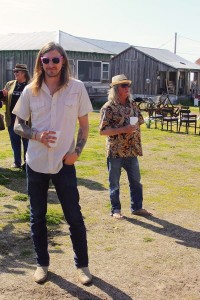 Two men standing outdoors, one wearing sunglasses.