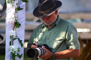 Man in hat taking photo with camera.