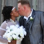 Bride and groom kissing with a bouquet.