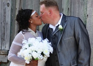 Bride and groom kissing with a bouquet.