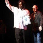 Two men holding an award for Blues music.