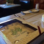 A wedding cake on a table with a gift box.