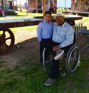 Man in wheelchair with a young boy.