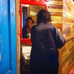 Woman in black robe looking in a mirror.