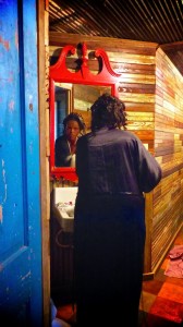 Woman in black robe looking in a mirror.