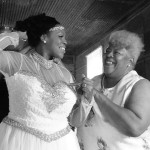 Bride getting dressed by her mother.