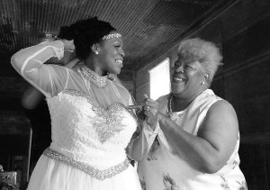 Bride getting dressed by her mother.