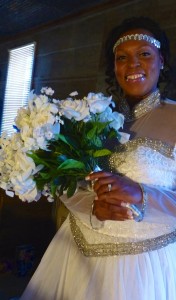 Bride holding white bouquet in wedding dress.