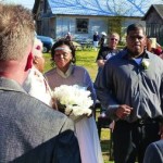 A man in a suit looks at a wedding ceremony.