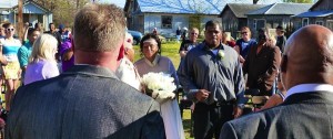 A man in a suit looks at a wedding ceremony.