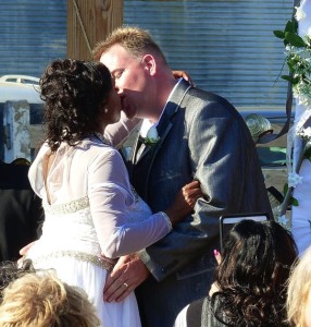 Bride and groom kissing at wedding ceremony.