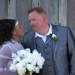 Bride and groom smiling with a bouquet.