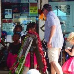 Group of people shopping at a market stall.