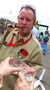 Man with cigar and drinks at a festival.