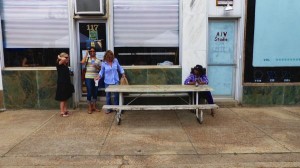 Three women sitting at a table outside a cafe.