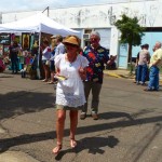 Woman in white dress at an art fair.