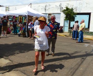 Woman in white dress at an art fair.