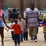 Group of people walking, including children.