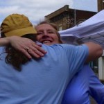 Man and woman hugging under a tent.