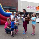 Children play on inflatable slide with adults.