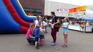 Children play on inflatable slide with adults.