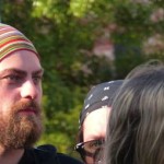 Man with colorful headband and beard looking right.