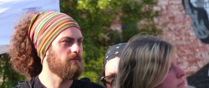 Man with colorful headband and beard looking right.